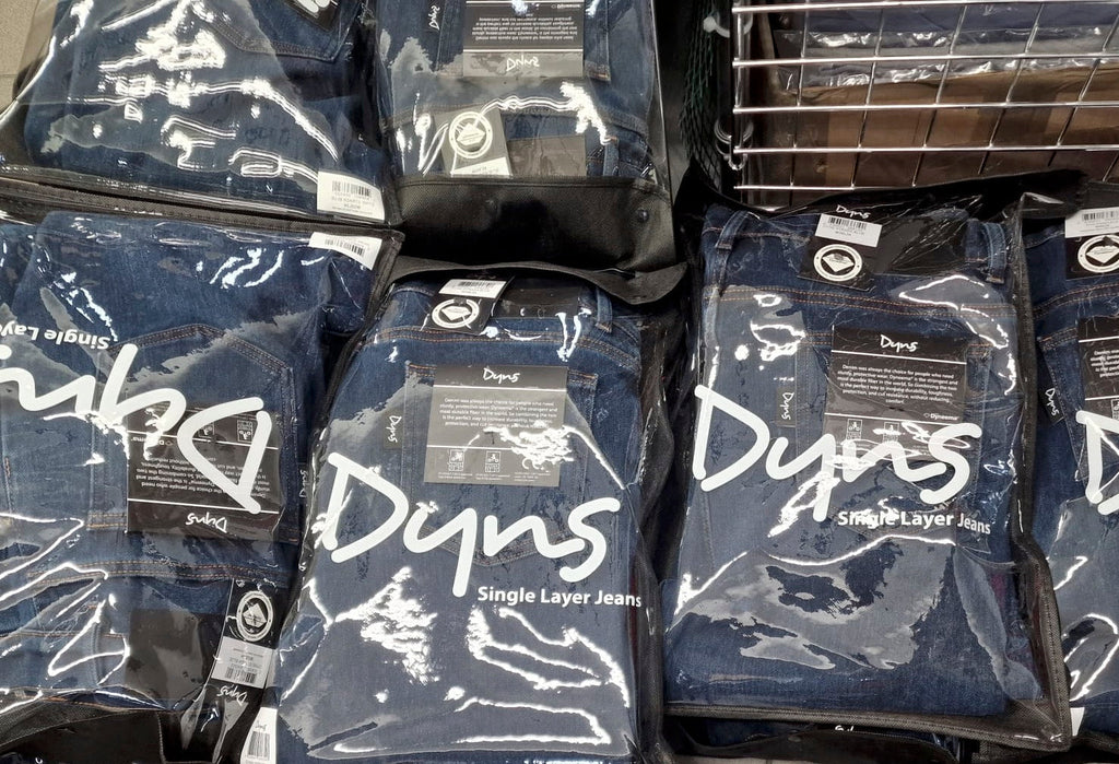 Packages of D Wyns jeans stacked on a metal rack.